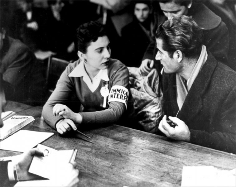 Interpreter Julianna Wolff aids a Hungarian Refugee. Library and Archives Canada, PA181009.