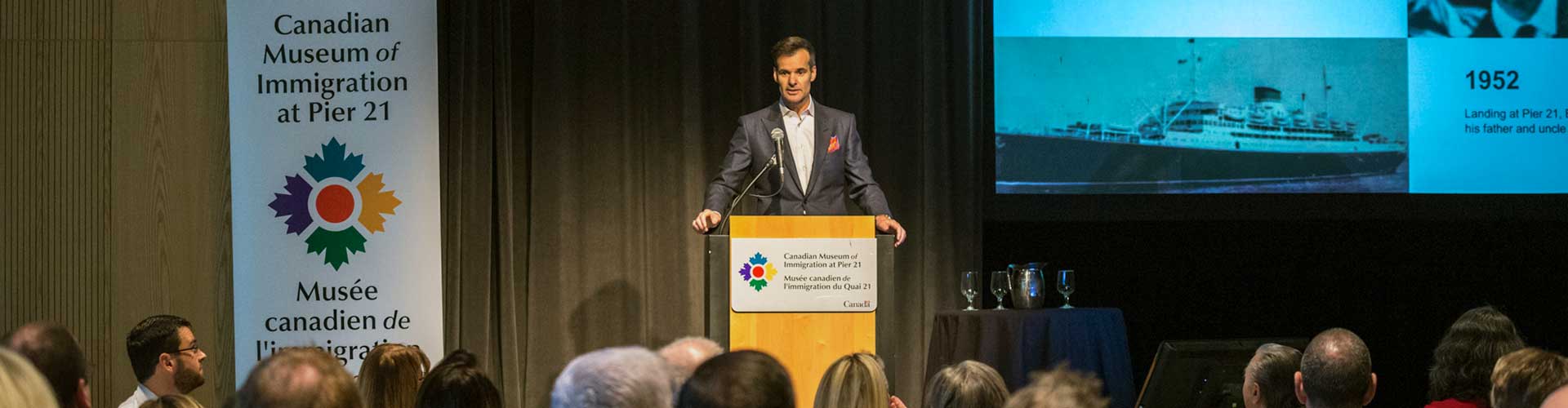 Man at a podium giving a speech to the audience.