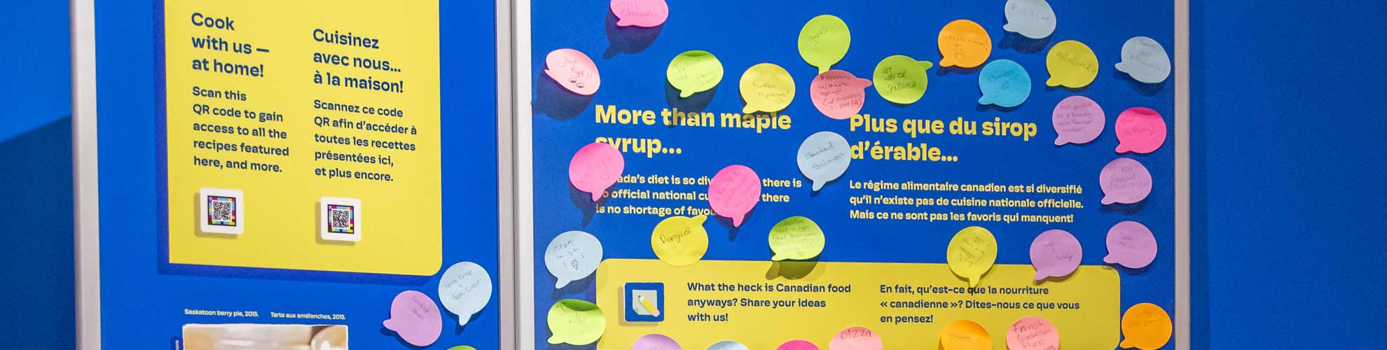 An exhibit panel with colourful sticky notes all over it, responding to the question what is Canadian food?