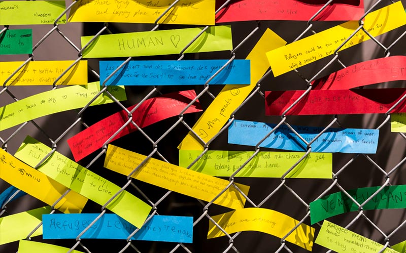 A close up of brightly coloured notes from visitors about refugees.