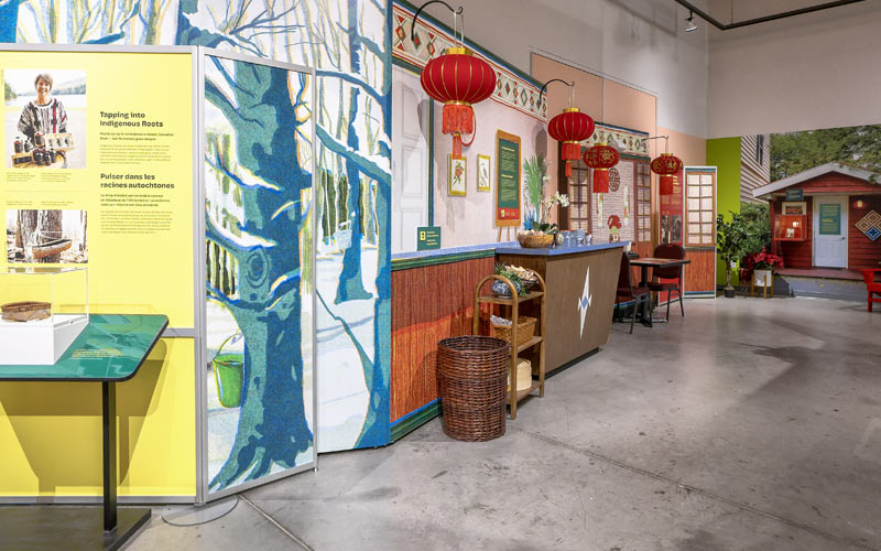 A wall of exhibition panels, including a model restaurant and information about Indigenous food history.