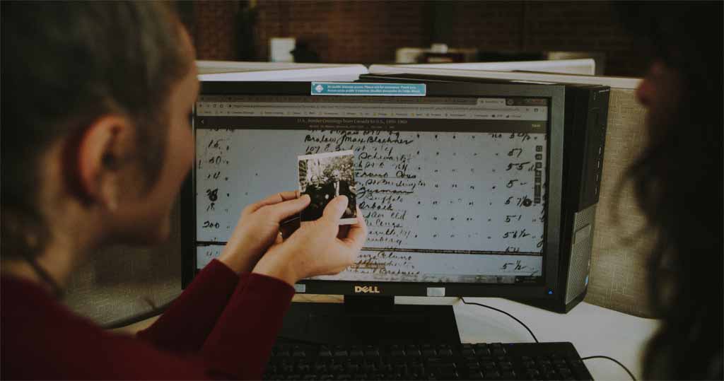 Person holding a wedding photo and looking at historical records.