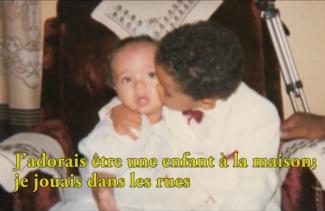 A well-dressed little boy kisses a baby sibling.