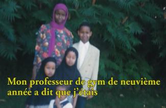 A woman in a beautiful pink dress and scarf stands next to three children.