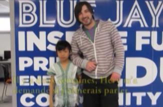 A young boy stands with a baseball player.