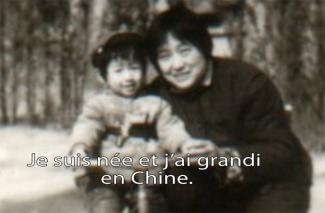 A mother bends down to hold her small baby girl.