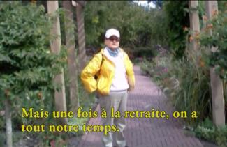 A man in a yellow sweater and white cap stands on a brick path.