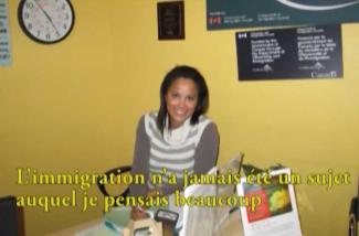 A pretty girl smiles at the camera as she is sitting at her desk.