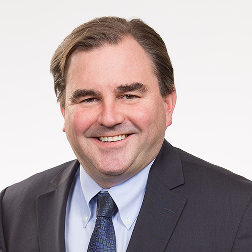 Headshot of Andrew Molson wearing a suit and smiling.