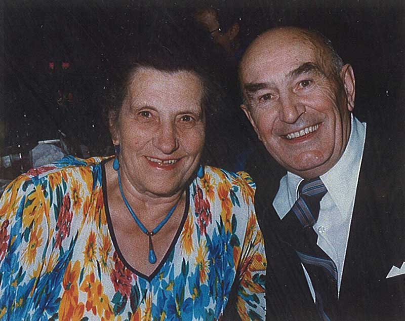 Handsome man and beautiful women sitting for photo, smiling.