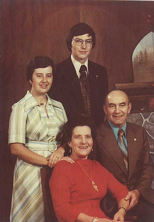Well dressed family is posing for a photo.