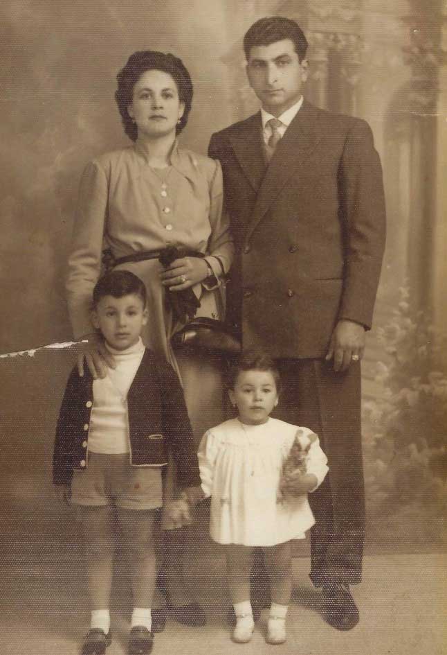 Family portrait with mother, father, son and daughter. Both children are holding teddy bears.