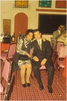 Well-dressed man and woman seated in a function room.