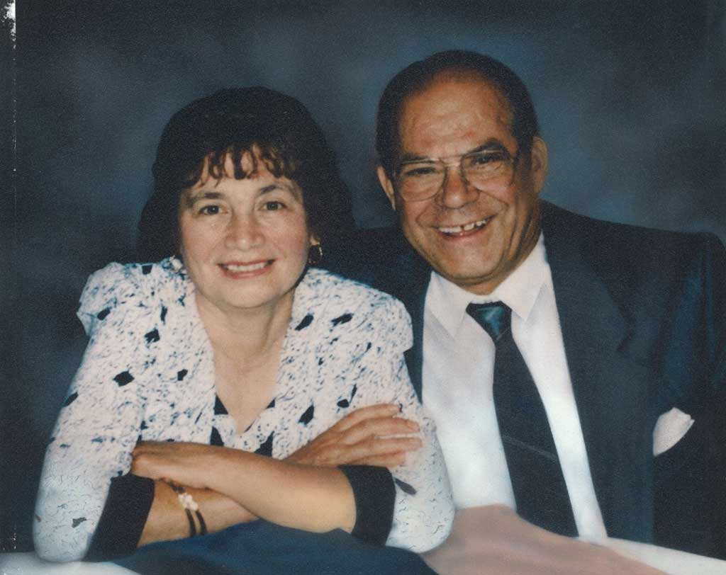 A young couple smile for their portrait.