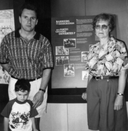 Ausma as an older woman, with her son and grandson at Pier 21 Museum.