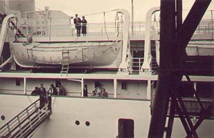 Gangplank and lifeboats on ship, as seen from dock.