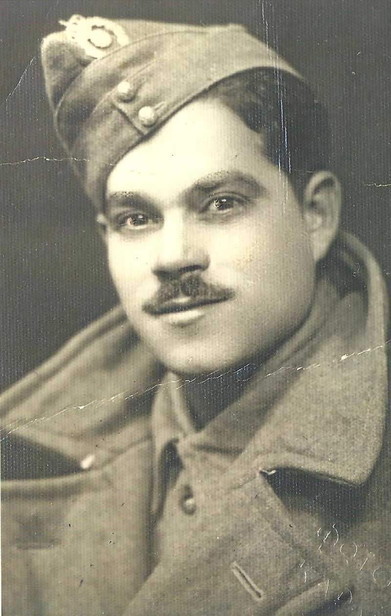 A young man in military uniform poses for a portrait.