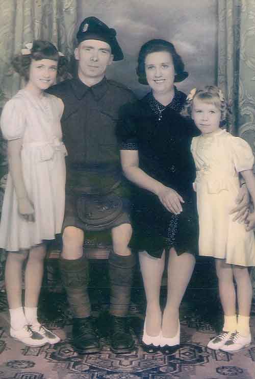A young couple are seated between two small children.