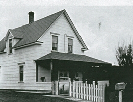 White house with picket fence and mailbox.