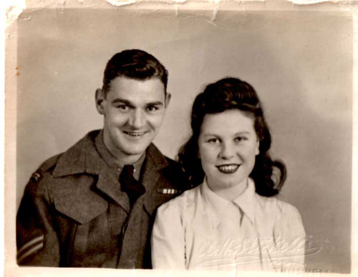 Old photograph of a man and woman standing next to each other.