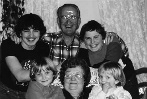 A young couple are sitting with their children.