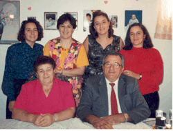 Older Pompilio and Rosa seated, with four young girls standing behind.