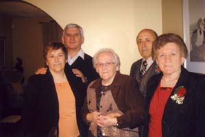 Three women standing with two men in behind.