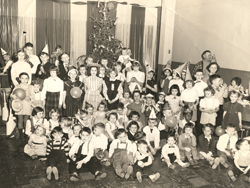 Large group of children, some sitting, some standing.