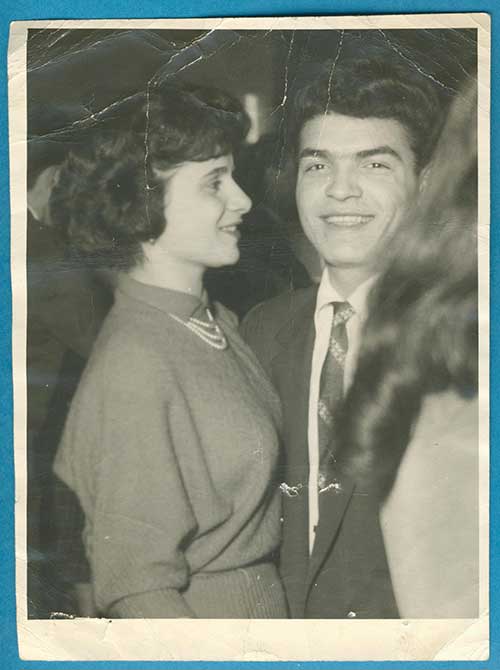 Well-dressed man and woman stand next to each other.