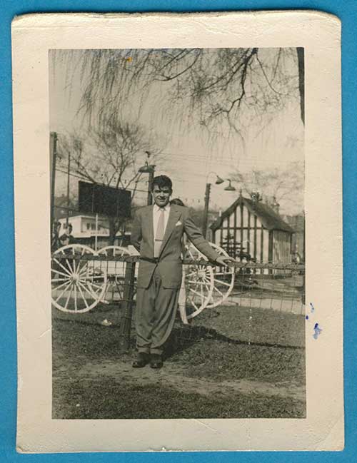 A young man is standing next to a railing.