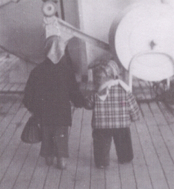 Two kids on the boat, turning their backs to the camera.