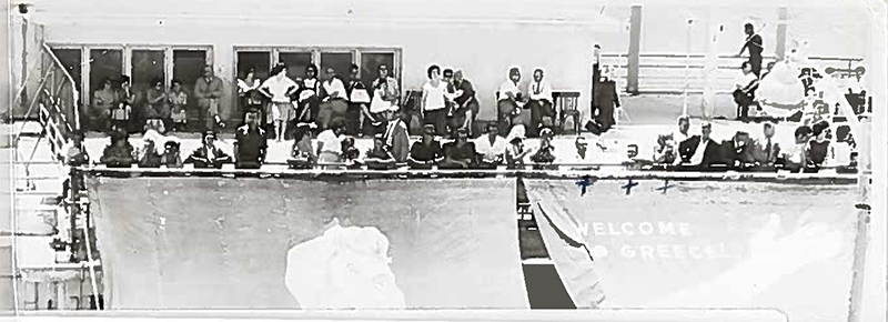 A large number of people standing on the ship deck.