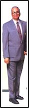 Small photo of a man standing in a grey three-piece suit.