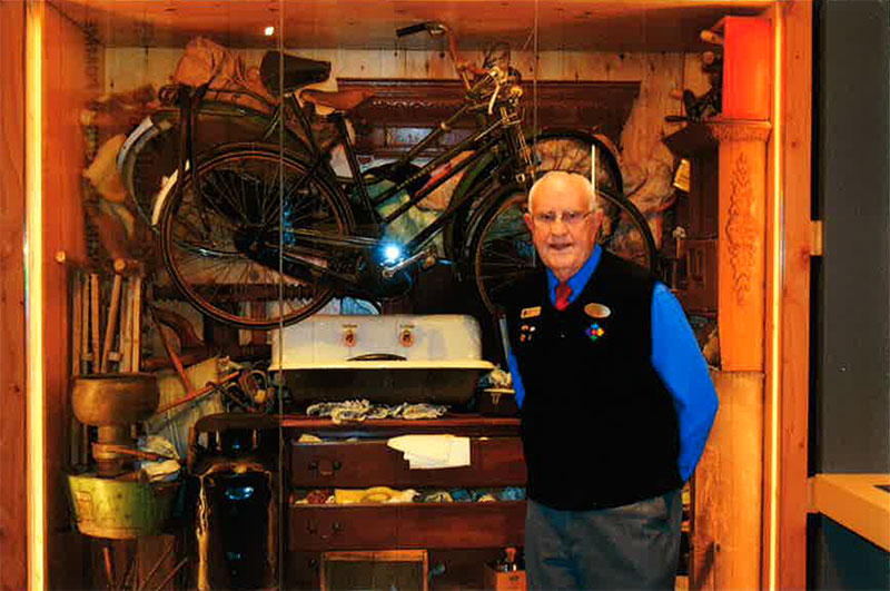 A man in a tour guide uniform stands in front of an example of a Dutch kist.