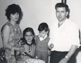 Man and woman standing with two small children between them.