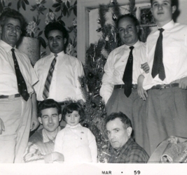 Two men seated with small child, four men in white shirts and ties standing behind them.
