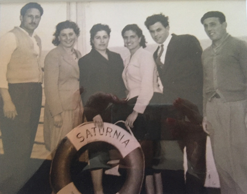 Black & white photo of the three beautiful ladies and three handsome men standing on ship deck holding a lifesaver.