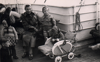 Mother with small child on bench, baby sitting in buggy.