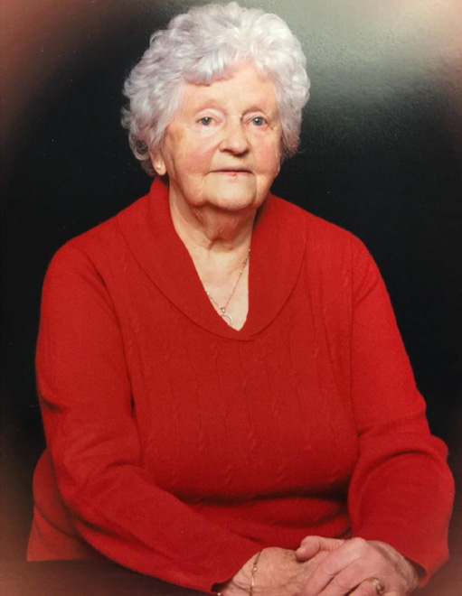 A young lady wearing a red dress is sitting for photo.