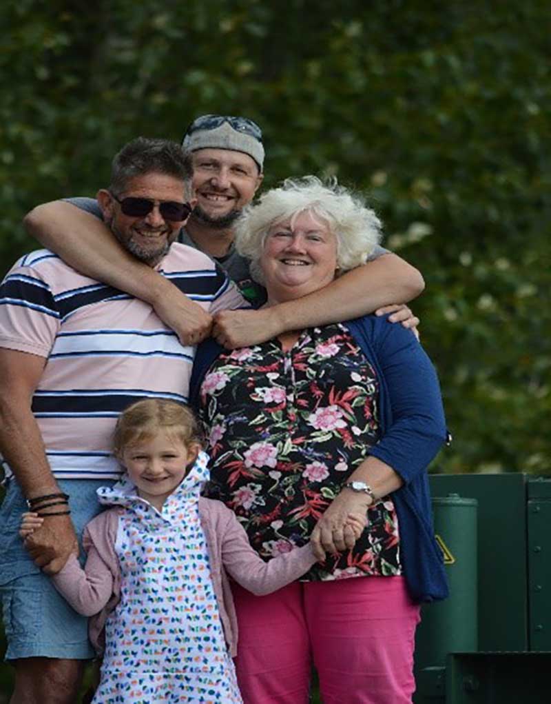Family of four hugging each other.
