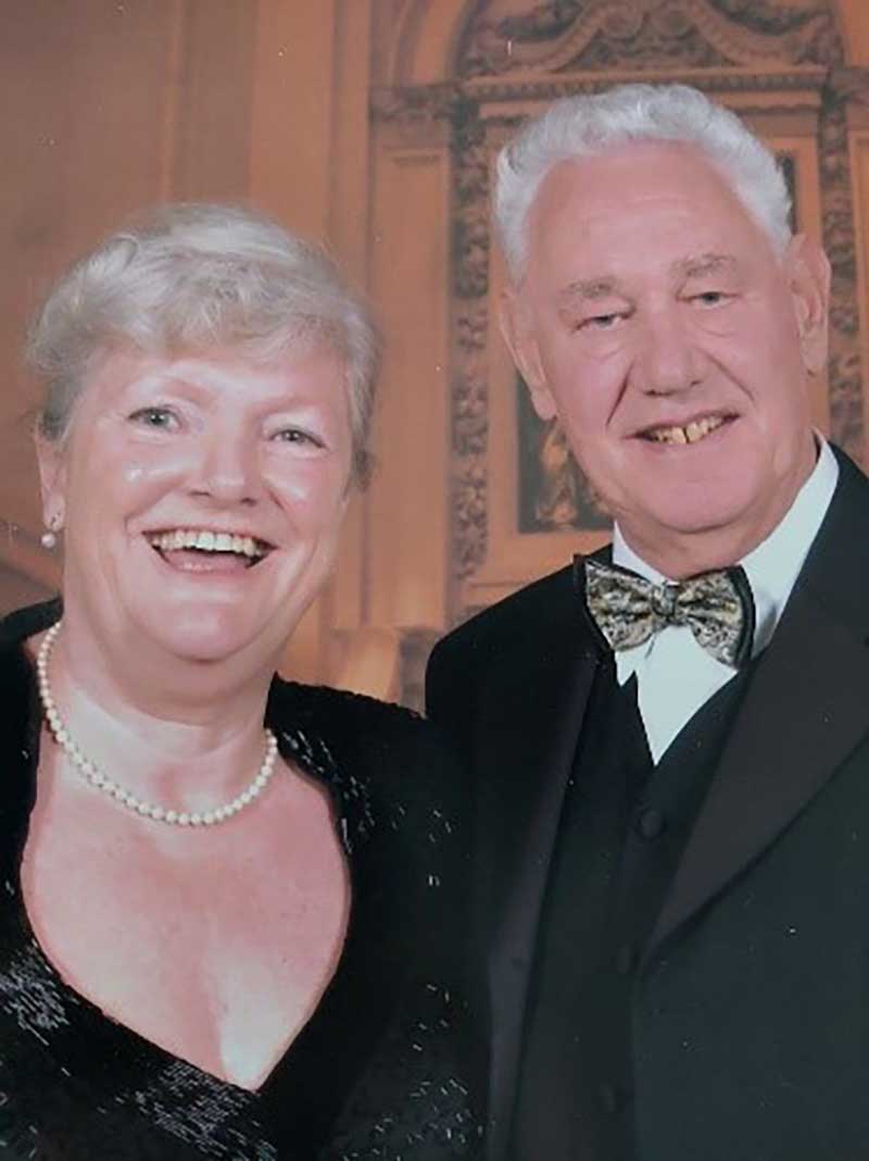 A well-dressed couple are celebrating a joyful occasion.
