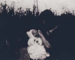 Old black and white photo of small baby in white.