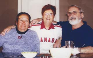 Two women and a man seated at a table.