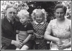 A mother and father and their two blond children between them.