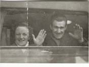 John and Kiersten waving at camera, from window of the train.