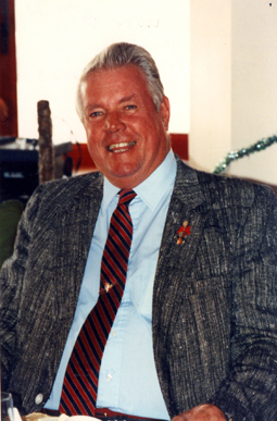 Jack older, sitting, wearing suit and tie.