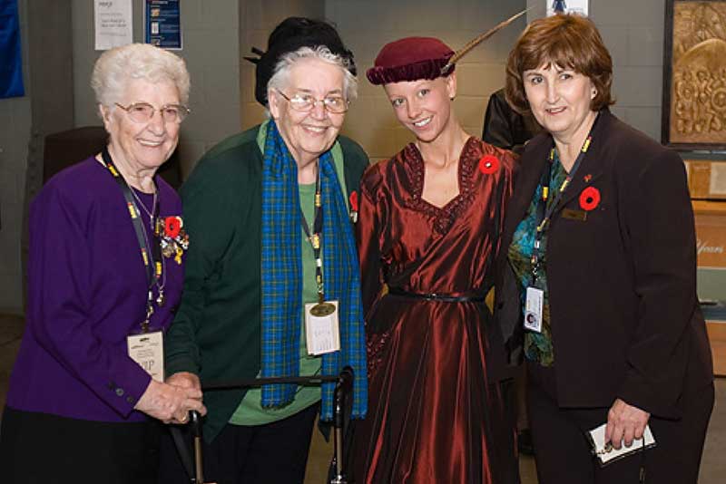 Four young women are wearing colourful dresses and posing for a photo.