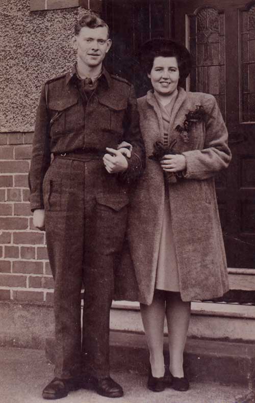 A young man and woman stand in front of a door.