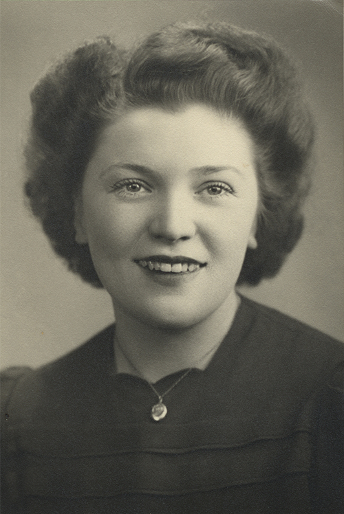 An old portrait of a young woman with short brown hair, she is wearing a locket.
