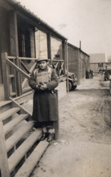 Young William standing at the bottom of steps of a wooden building.